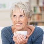 lady smiling with teacup cupped in hands